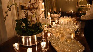 A table set for a formal event with a silver tray, wine glasses, and a floral centerpiece. - Terrell House Bed & Breakfast (New Orleans)