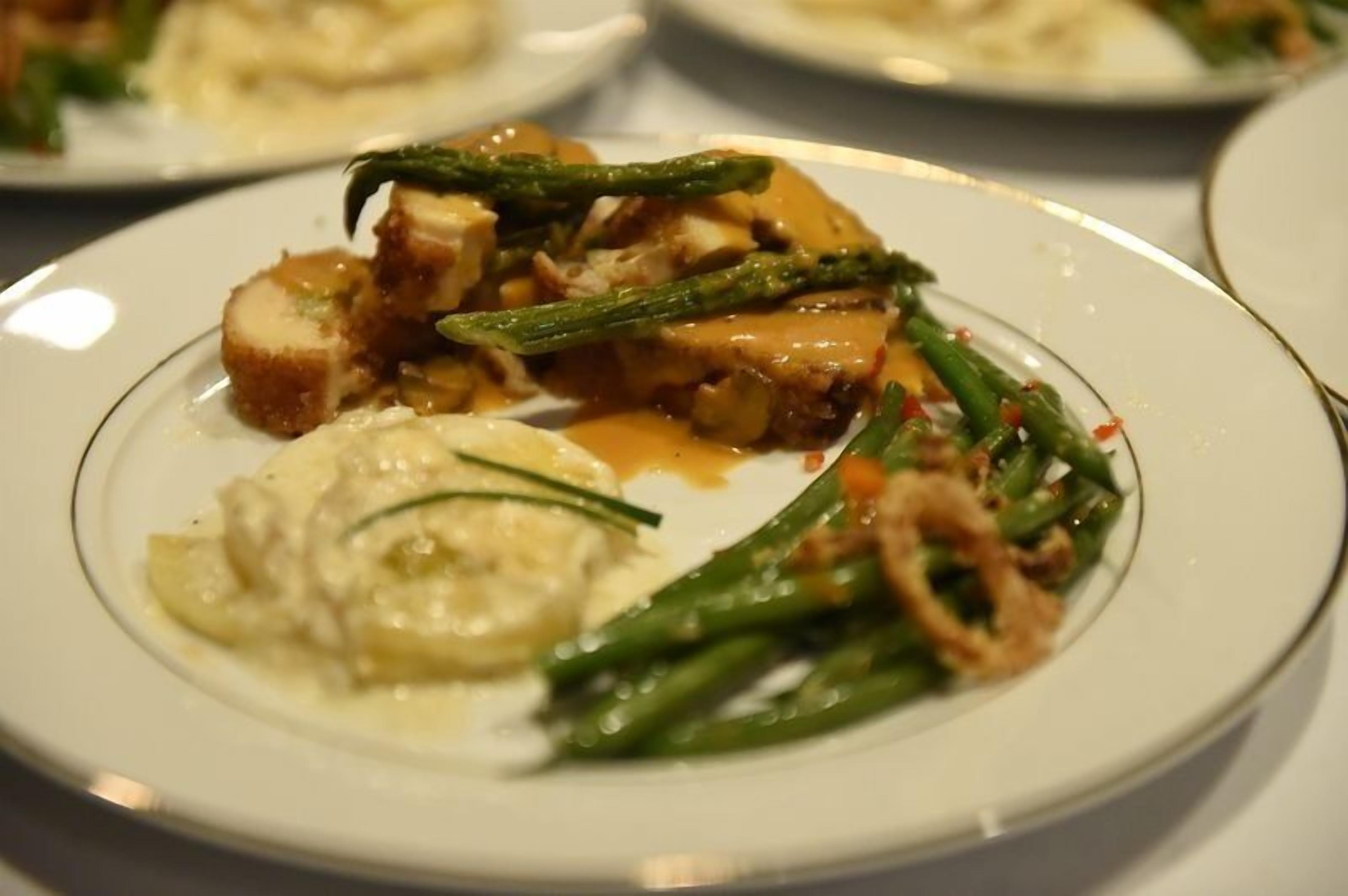 Un plato de comida con espárragos, champiñones y salsa cremosa.