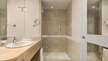 Ein modernes Badezimmer mit einem Doppelwaschbecken, einer Duschkabine aus Glas und einer begehbaren Dusche.