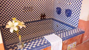 Bathroom features a checkered tile pattern and a bathtub with a nearby vase.