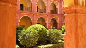 Un patio con un edificio que presenta múltiples arcos y balcones.