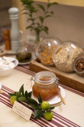 A table with jars of preserves, a bowl of sweets, and a sign indicating the type of jam. - Monasterio de San Francisco (Palma del Rio)