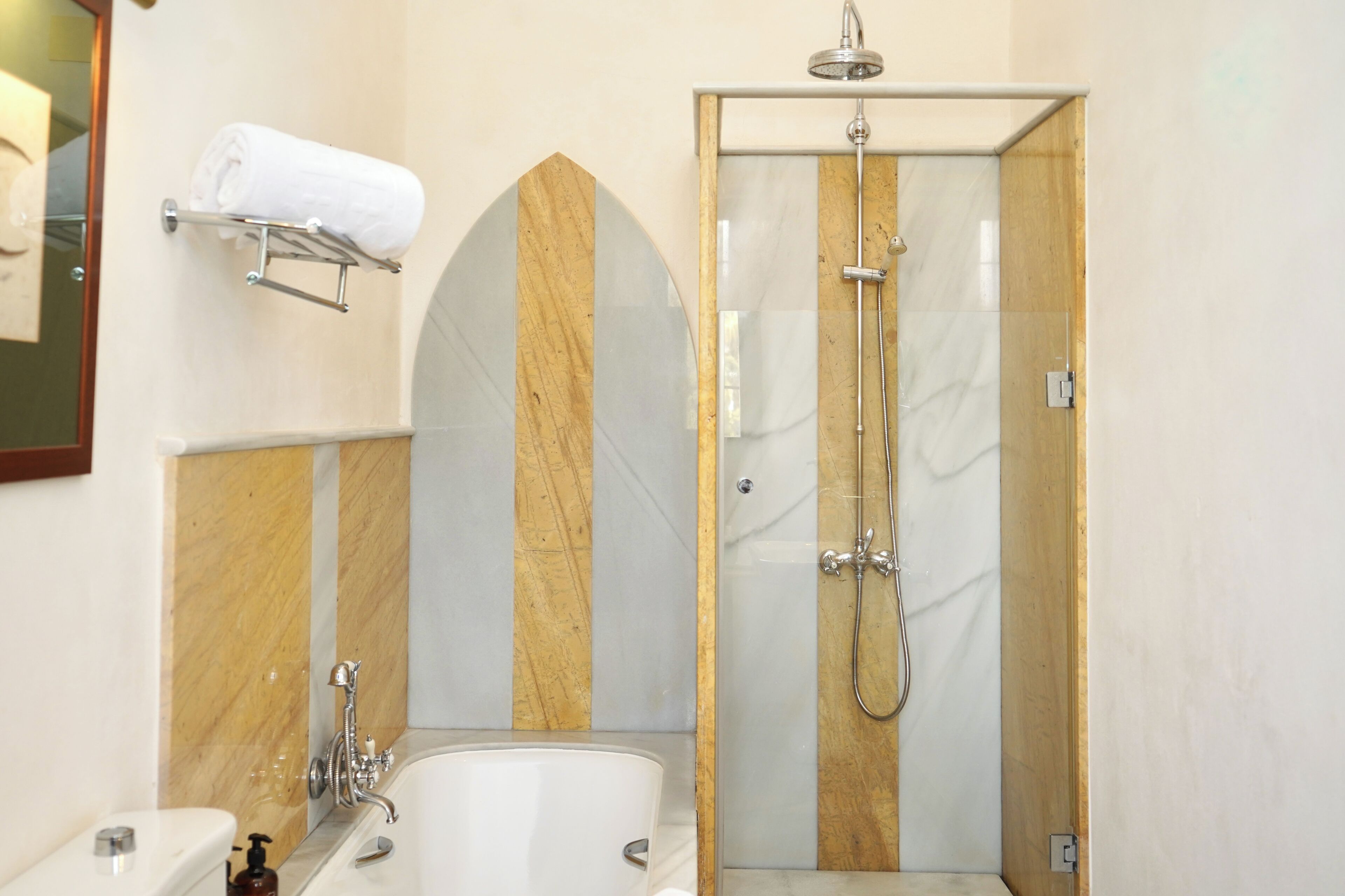 A bathroom with a bathtub, a shower, and a towel rack.