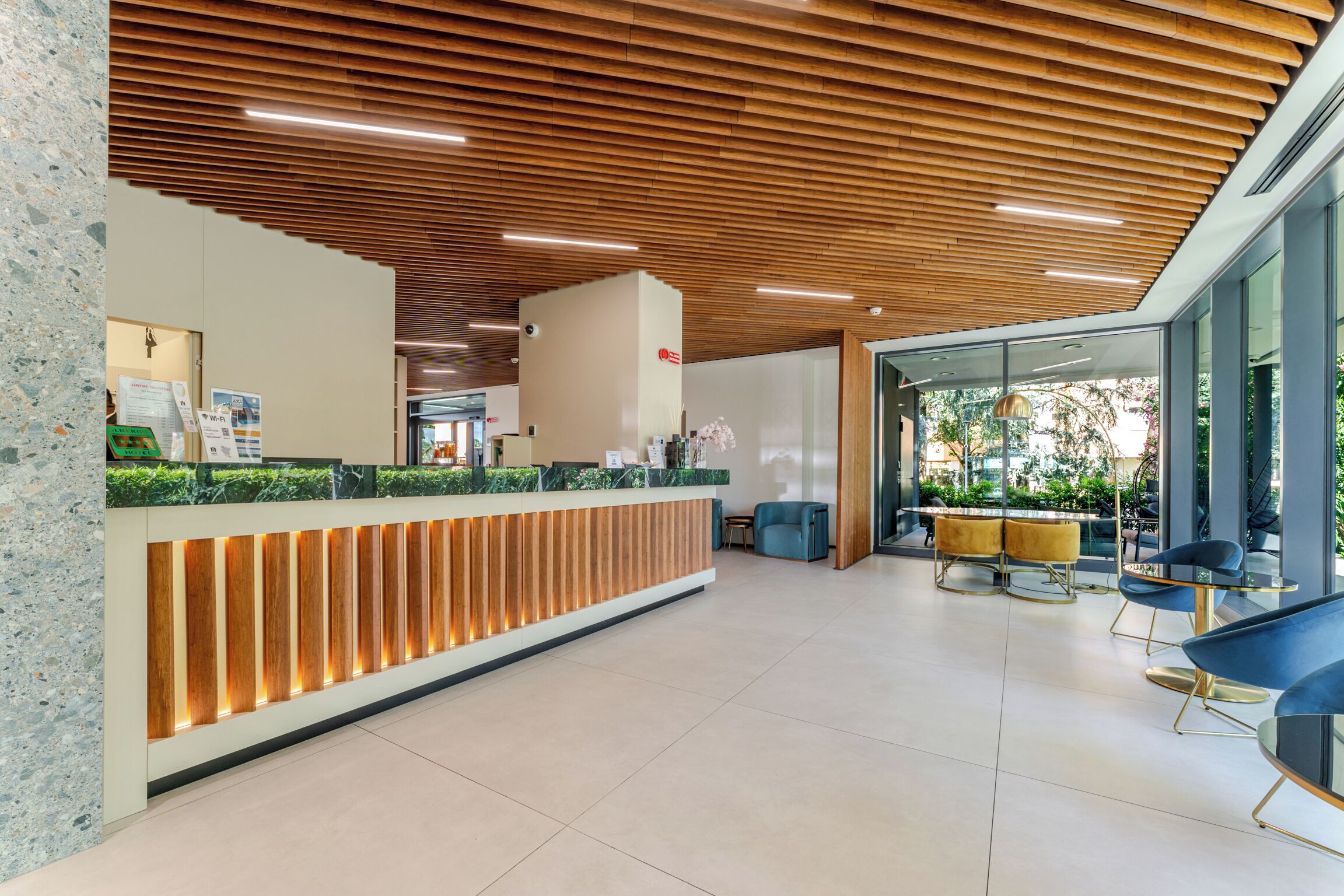 A reception area with a wooden reception desk, glass walls, and modern seating.