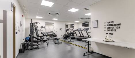 A gym with exercise equipment, motivational posters, and a clean, modern design.