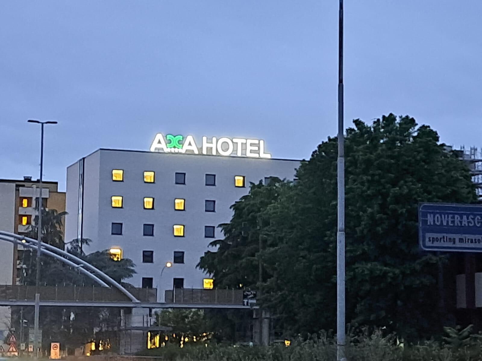 Un hôtel avec une enseigne indiquant « HÔTEL ACA » et une entrée bien visible.