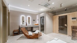 Un baño moderno con una silla de baño de madera, un espejo grande, un lavabo y una cabina de ducha de vidrio.