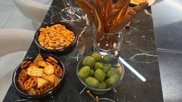 Une table de buffet proposant divers amuse-gueules, notamment des bretzels, des olives et des chips.