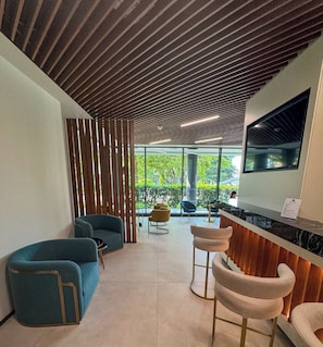 Un interior moderno con techo de madera, zona de bar y asientos.