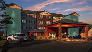 Ett Comfort Inn-hotell med en röd och blå fasad, flera våningar och ett takförsett parkeringsområde.