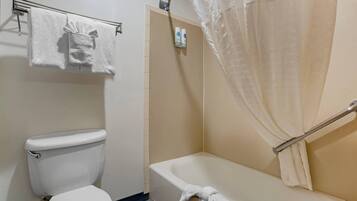 Un baño con inodoro, bañera y cortina de ducha.