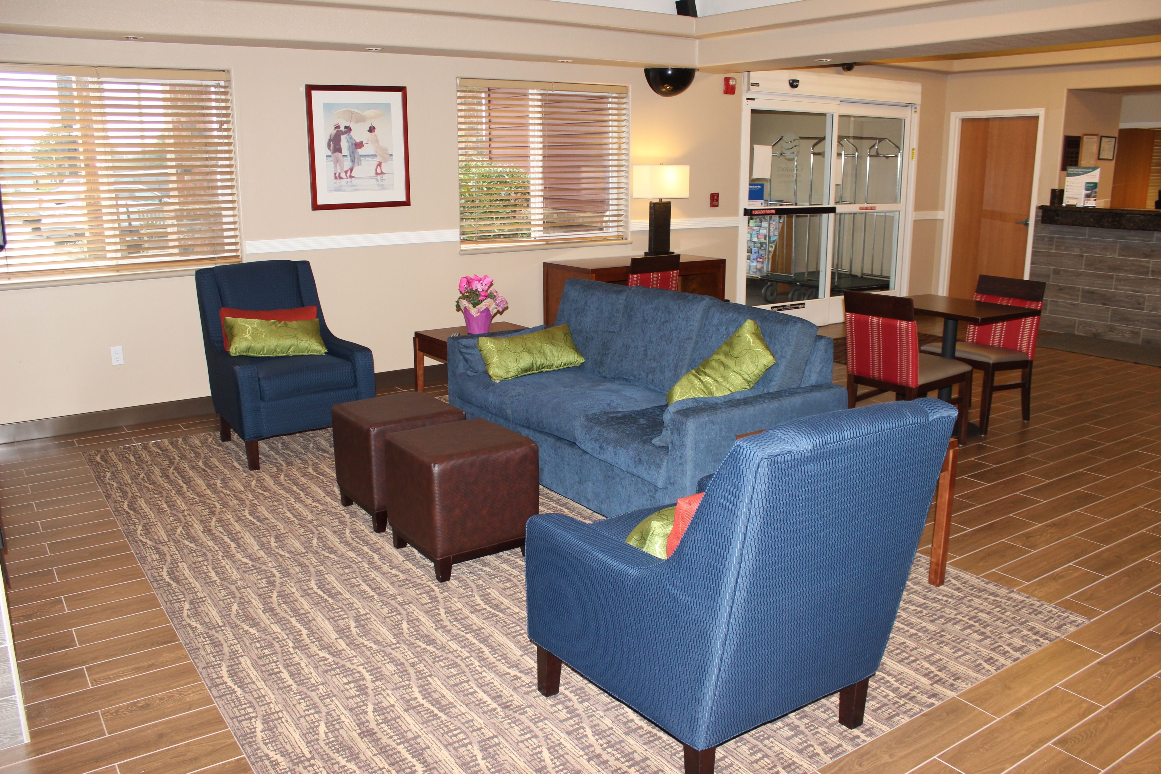 Ein Wohnzimmer mit einem blauen Sofa, passenden Sessel, einem Couchtisch und einem gemusterten Teppich.