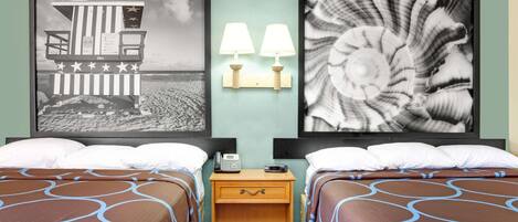 A hotel room with two beds, a wooden nightstand with a phone, and wall-mounted lamps.