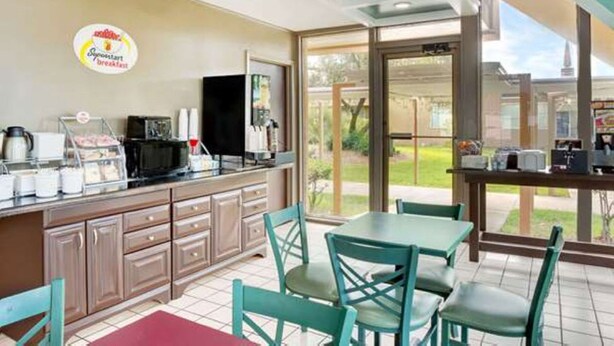 A breakfast area with a counter, chairs, and a view of the outdoors. - Super 8 by Wyndham St. Augustine (St. Augustine)