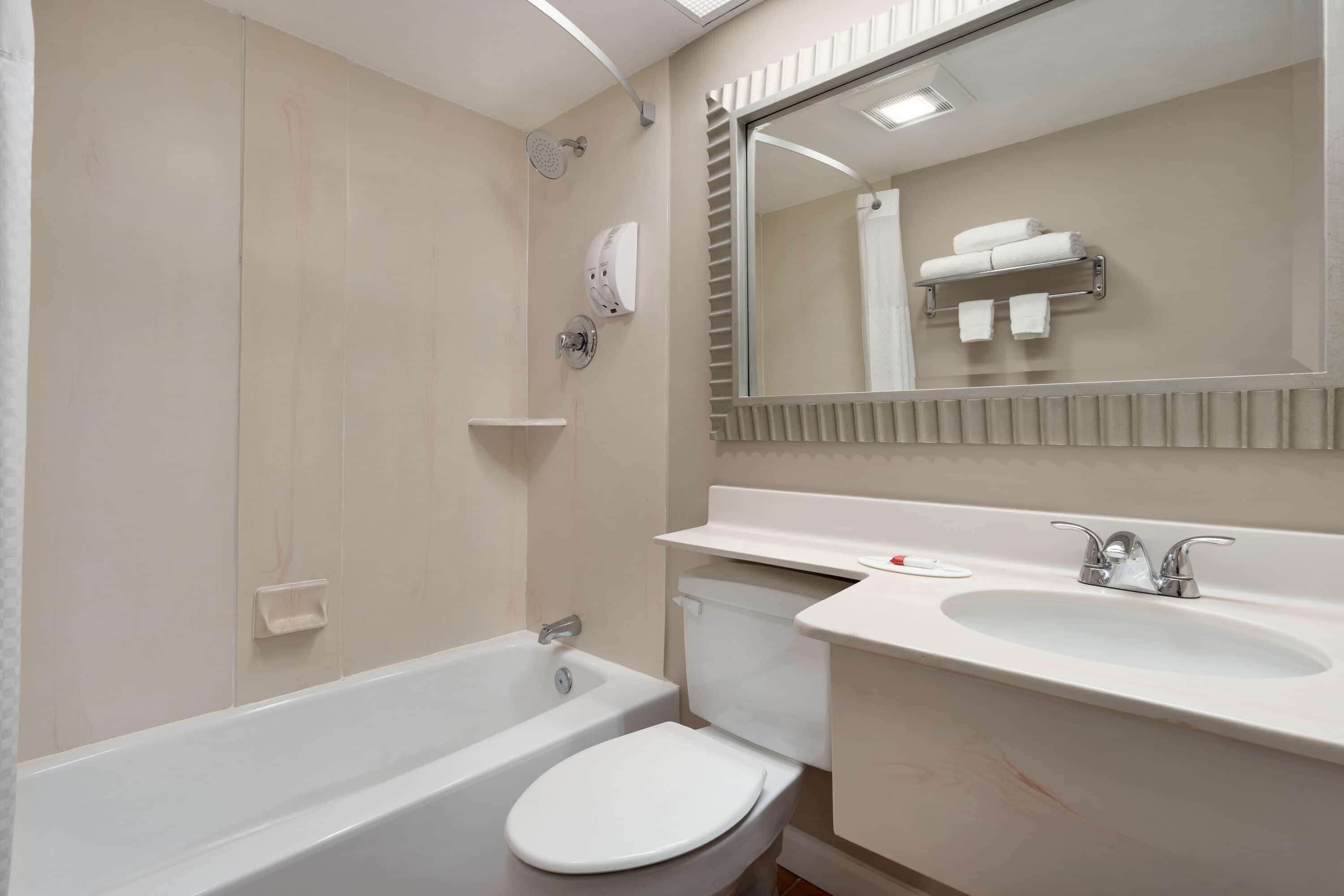 A modern bathroom with a bathtub, toilet, and sink.