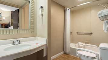 Un baño con lavamanos, espejo, secador de pelo, ducha e inodoro.