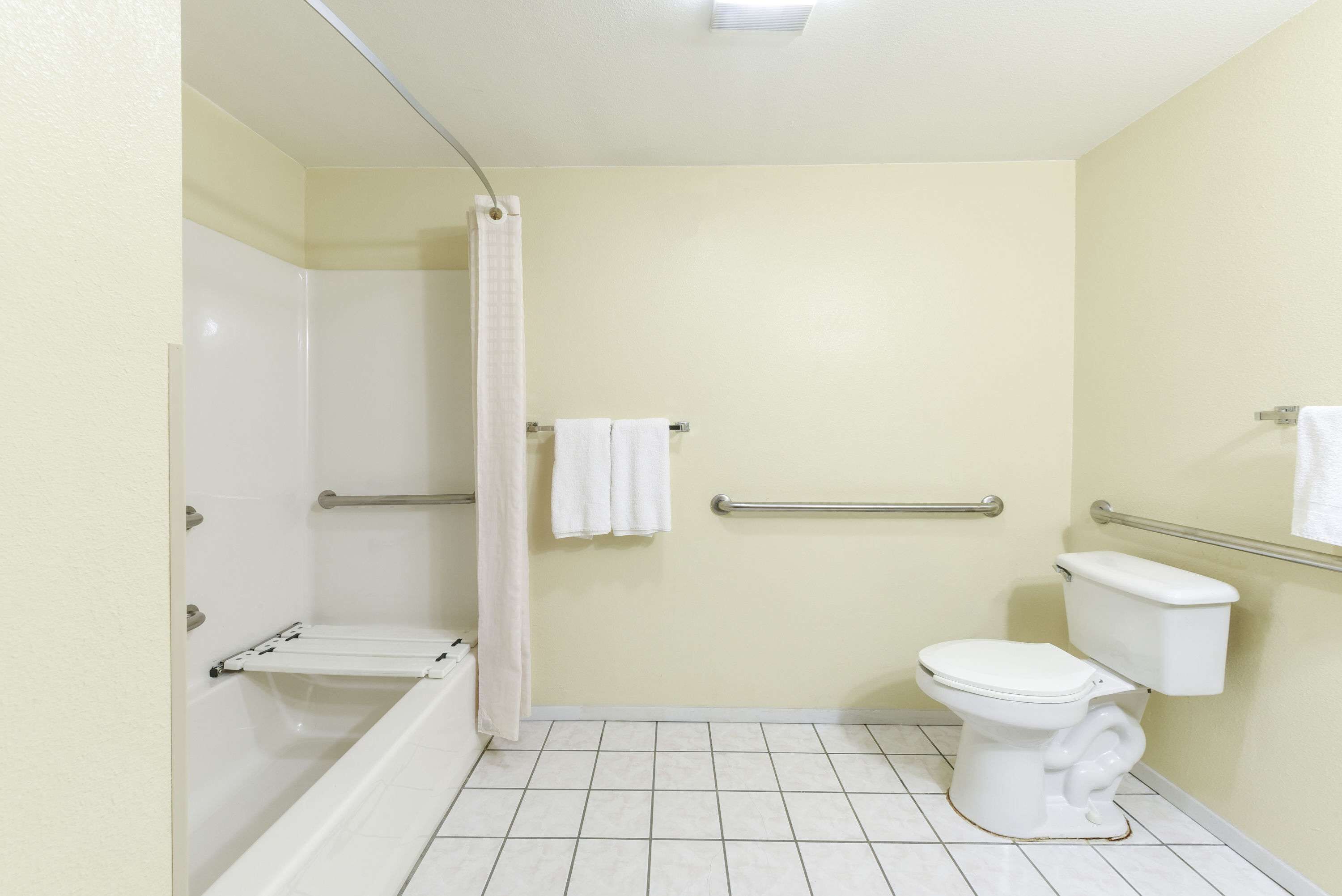 A bathroom with a bathtub, toilet, and shower curtain.