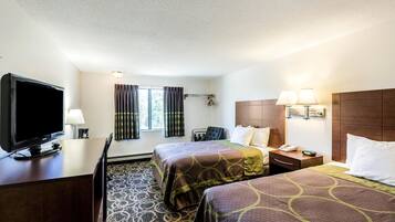 A hotel room with two beds, a TV, a desk, and a window with curtains.