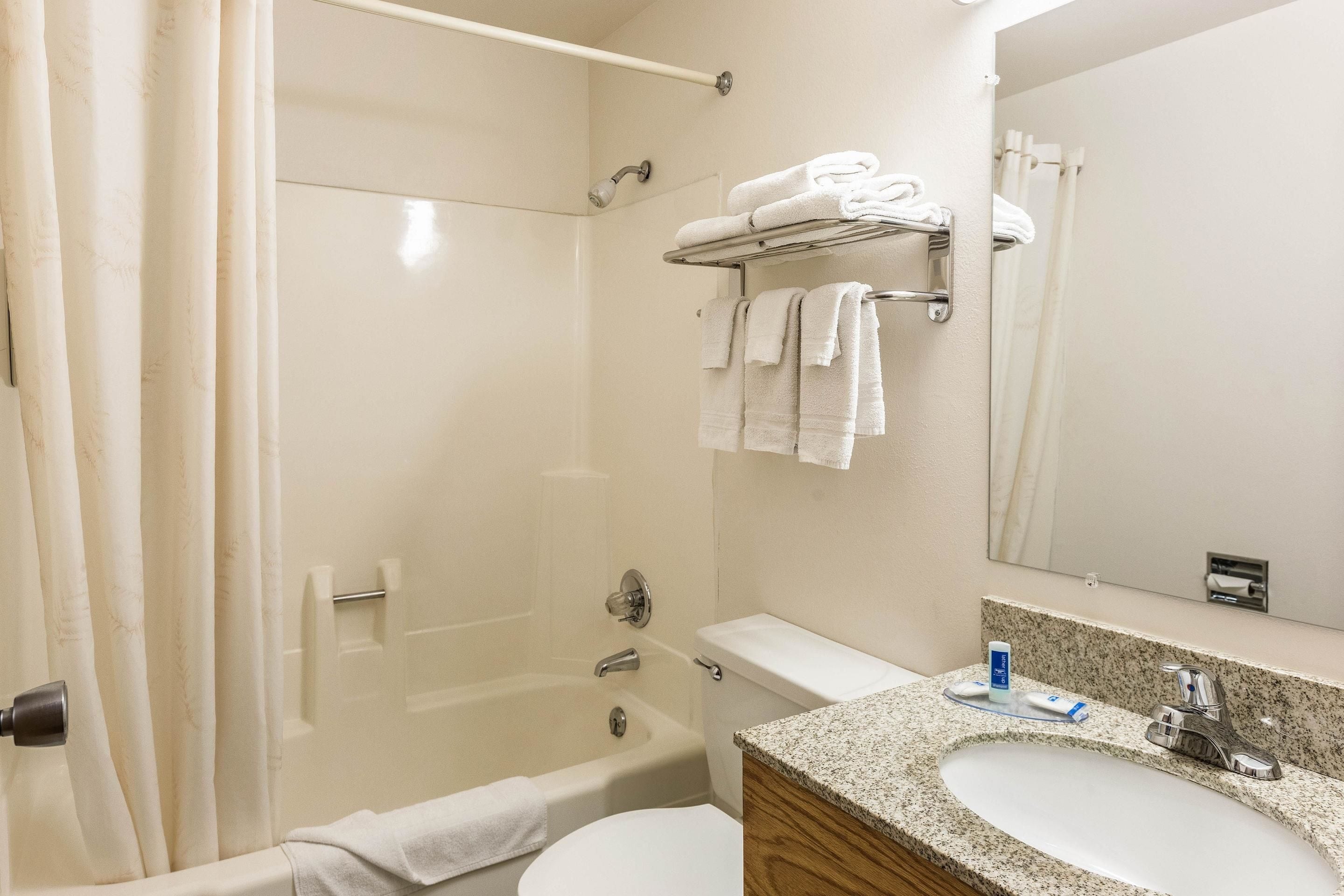 A bathroom with a bathtub, toilet, sink, and towel rack.