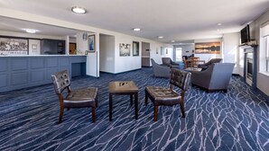 A hotel lobby with a reception desk, seating area, and artwork on the walls. - Super 8 by Wyndham Jackson MN (Jackson)