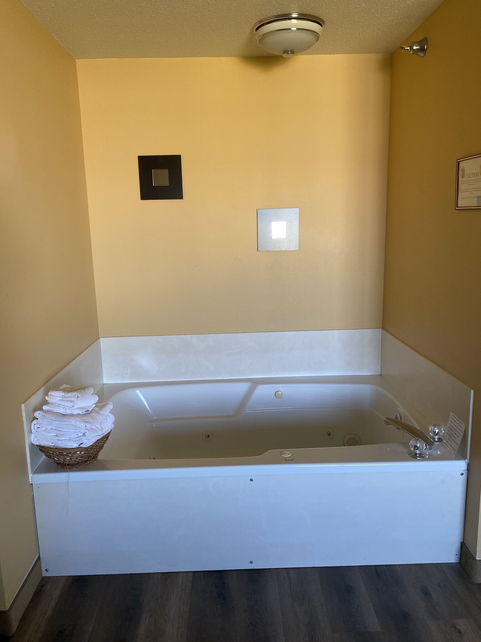Une grande baignoire blanche, avec un panier rempli de serviettes pliées, posé sur le bord.
