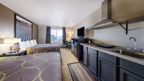 A hotel room with two beds, a kitchenette, a TV, and a window with curtains. - Super 8 by Wyndham Jackson MN (Jackson)