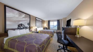 A hotel room with two beds, a desk, a chair, a TV, and a large window.