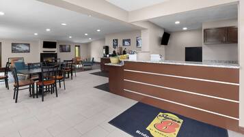 A hotel lobby with a reception desk, seating area, and a fireplace.