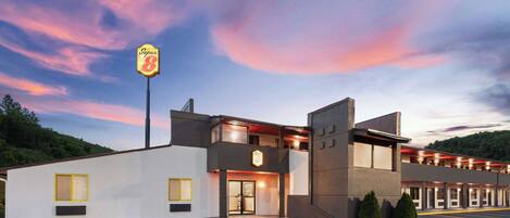 Um hotel Super 8 com design moderno, apresentando uma estrutura em dois andares e estacionamento.