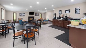 Un hall de hotel con comedor, cocina y chimenea.