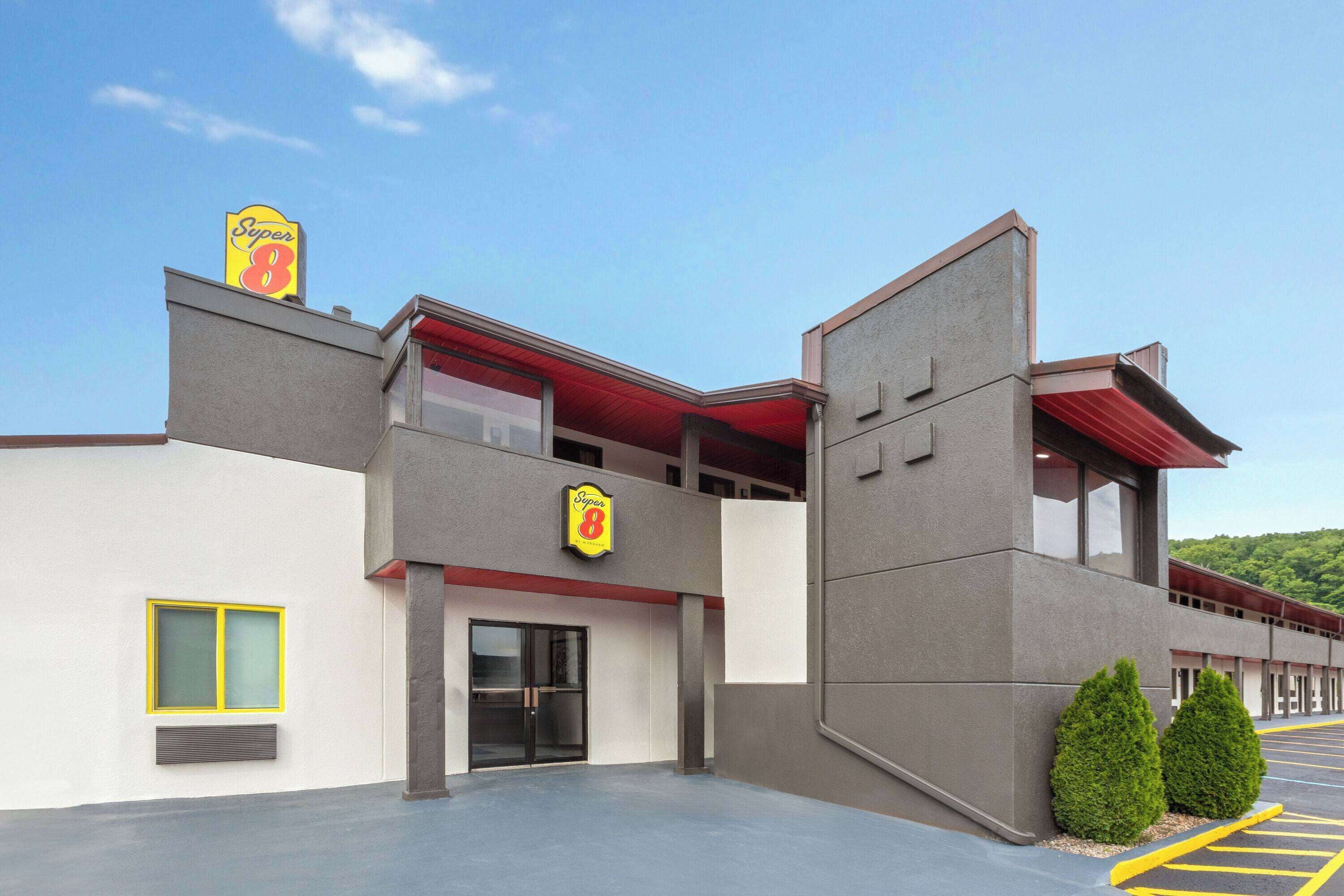 A modern building with a Super 8 sign, a large glass entrance, and a parking lot.