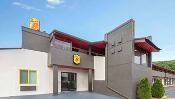 A modern building with a Super 8 sign, a large glass entrance, and a parking lot.