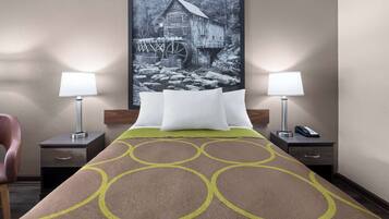 A hotel room with a bed, two bedside tables with lamps, a chair, and a large framed picture on the wall.