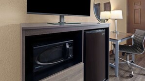 Una kitchenette compacta con televisión de pantalla plana, microondas y refrigerador.