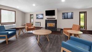 Una sala de estar moderna con chimenea, asientos en tonos azul y naranja, y un televisor de pantalla plana.