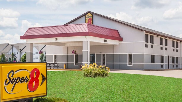 A Super8 hotel with a red roof and white walls, featuring a large signboard in front. - Super 8 by Wyndham Shipshewana (Shipshewana)