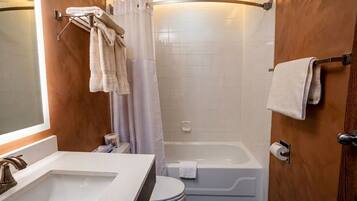 Un baño con lavamanos, inodoro y bañera blancos.