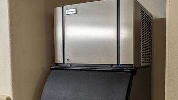 Un frigorífic petit i d'acer inoxidable amb un panell frontal negre i un etiquetatge que diu "Ice-O-Matic".