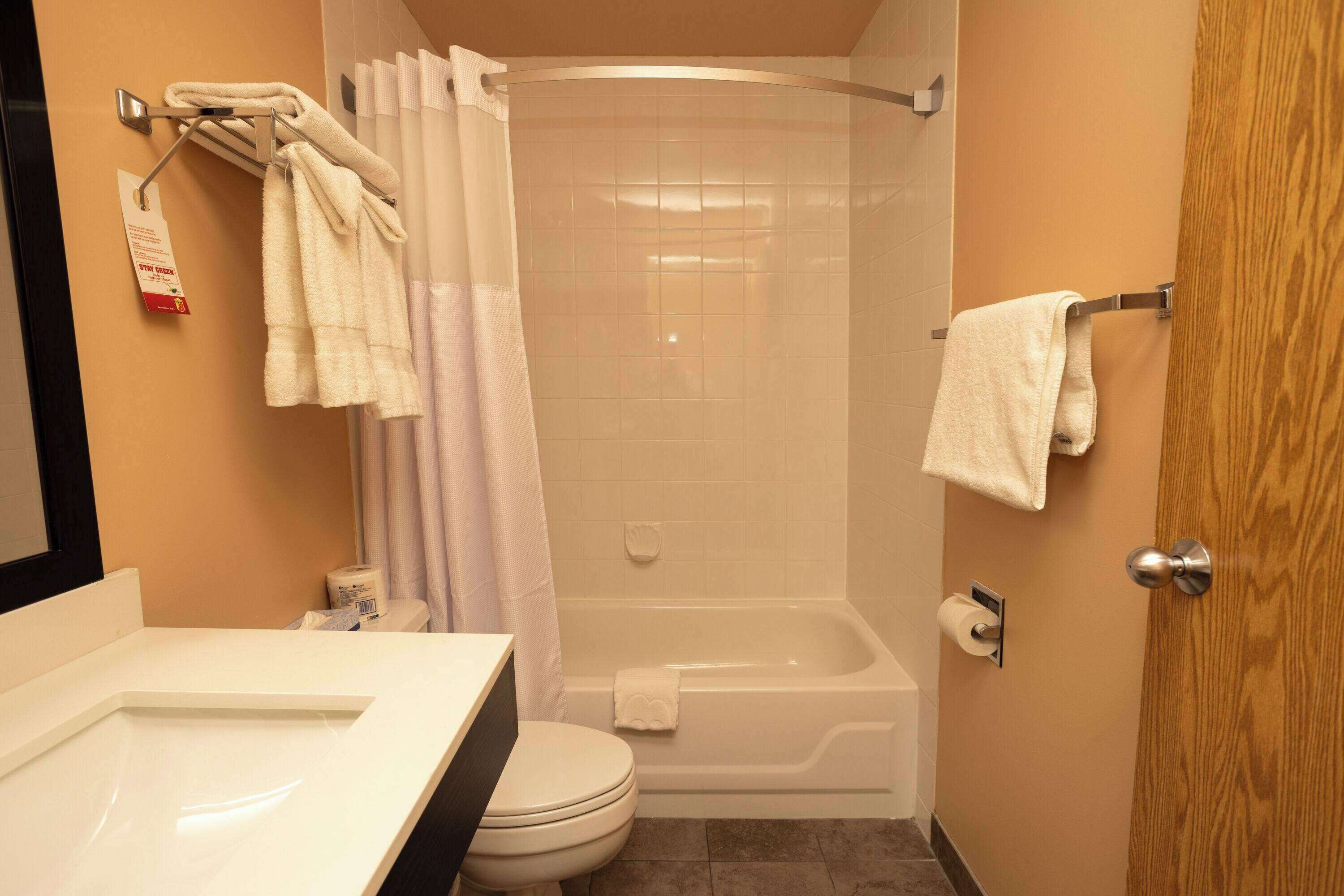 A bathroom with a toilet, sink, shower, and bathtub.