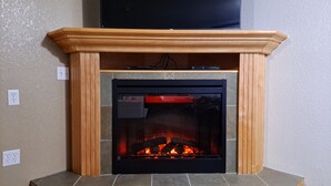 A fireplace with a stone surround and a wooden mantel. - Super 8 by Wyndham Three Hills AB (Three Hills)