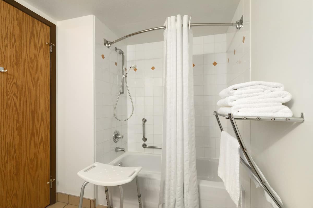 Ein Badezimmer mit Dusche, Toilette und Handtuchhalter.