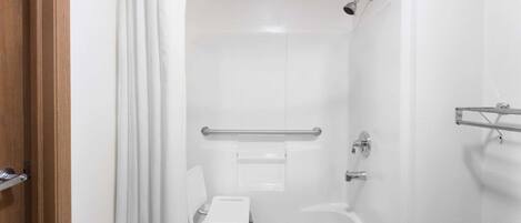 Ein modernes Badezimmer mit Dusche, einer kleinen Stehgehhilfe und einer Haltestange.