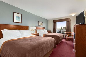 A hotel room with two beds, a television, a desk, and a window with curtains. - Super 8 by Wyndham Yellowknife (Yellowknife)
