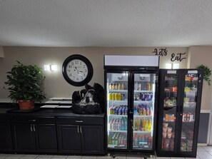 A kitchen with a clock, a refrigerator, and a potted plant. - Super 8 by Wyndham Black Mountain/Asheville East (Black Mountain)