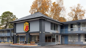 A motel with a 'Super 8' sign, multiple balconies, and a parking lot.