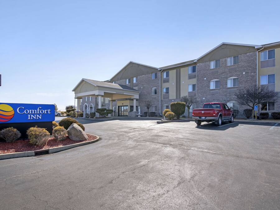 Un hotel Comfort Inn con un parcheggio, un furgone pick-up rosso e un cielo azzurro limpido.
