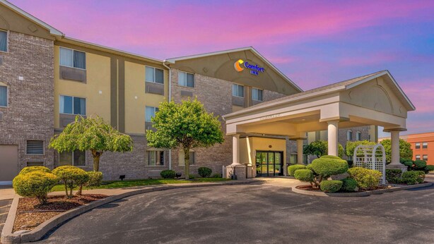 A Comfort Inn hotel with a brick facade, a covered entrance, and well-maintained landscaping. - Comfort Inn Fremont (Fremont)