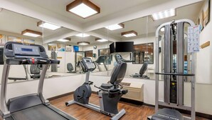 A gym with a treadmill, elliptical, and weight machine. - Comfort Inn Fremont (Fremont)