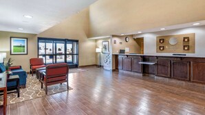 A spacious lobby with a reception desk, seating area, and large windows offering a view of the outdoors. - Comfort Inn Fremont (Fremont)