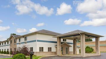 A two-story motel with a covered entrance and a parking lot.